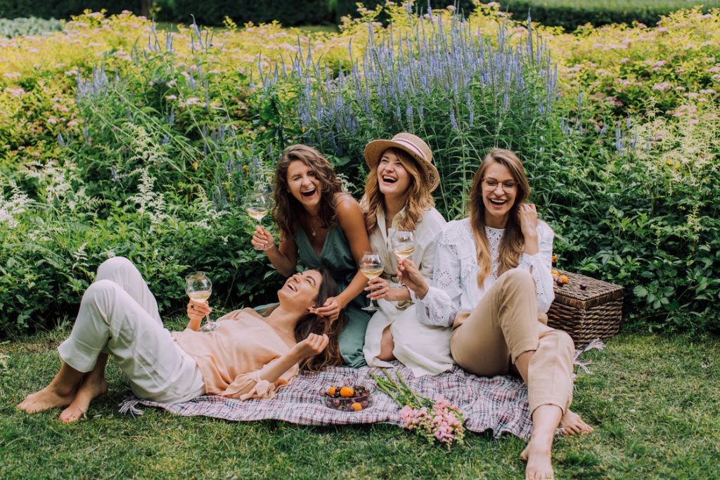 Four women laughing happily while in front of a lavender garden